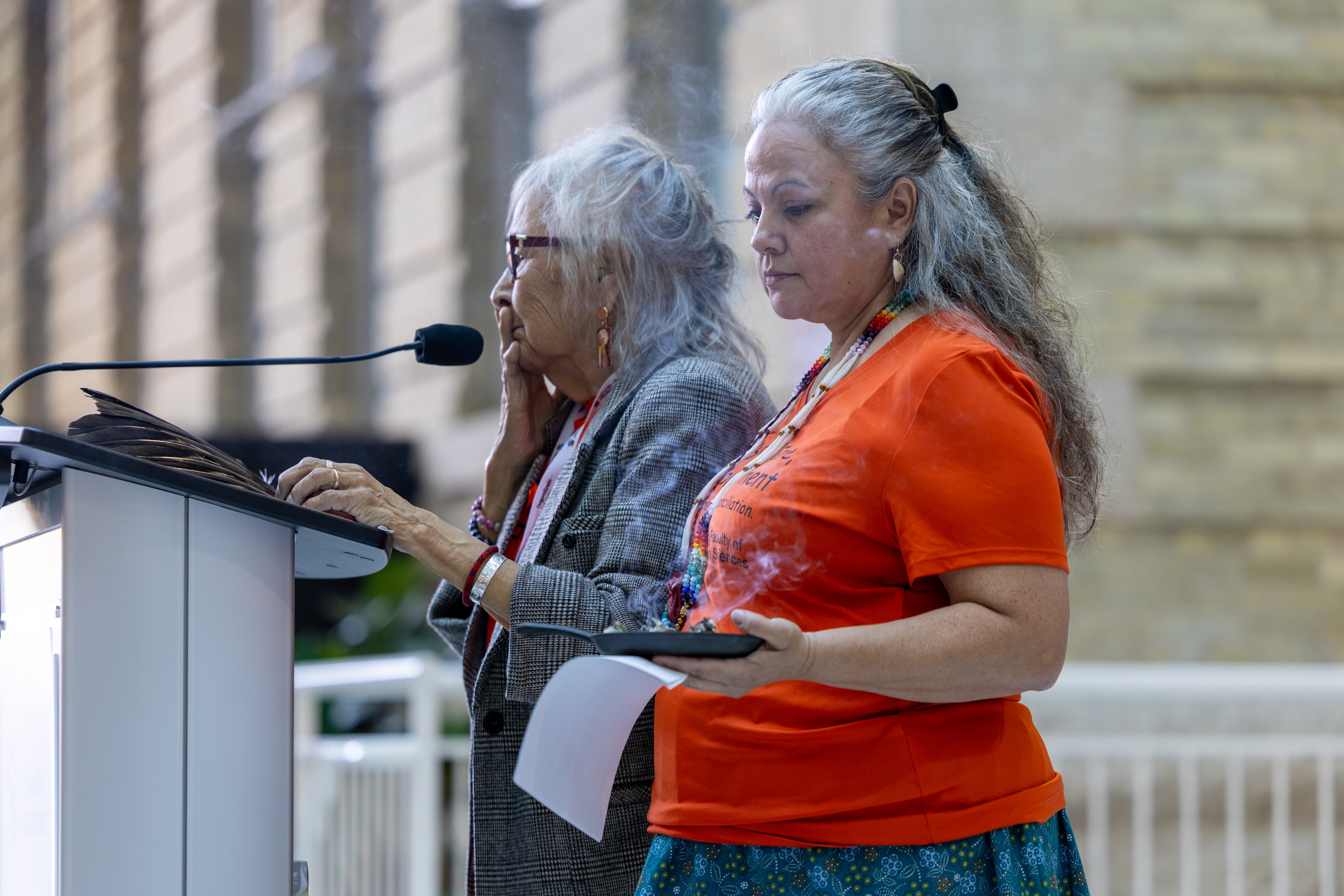 Elder Margaret Lavallee, Elder-in-residence at Ongomiizwin, addresses the crowd while Chantal Daniels, director of Ongomiizwin - Education, stands beside her.