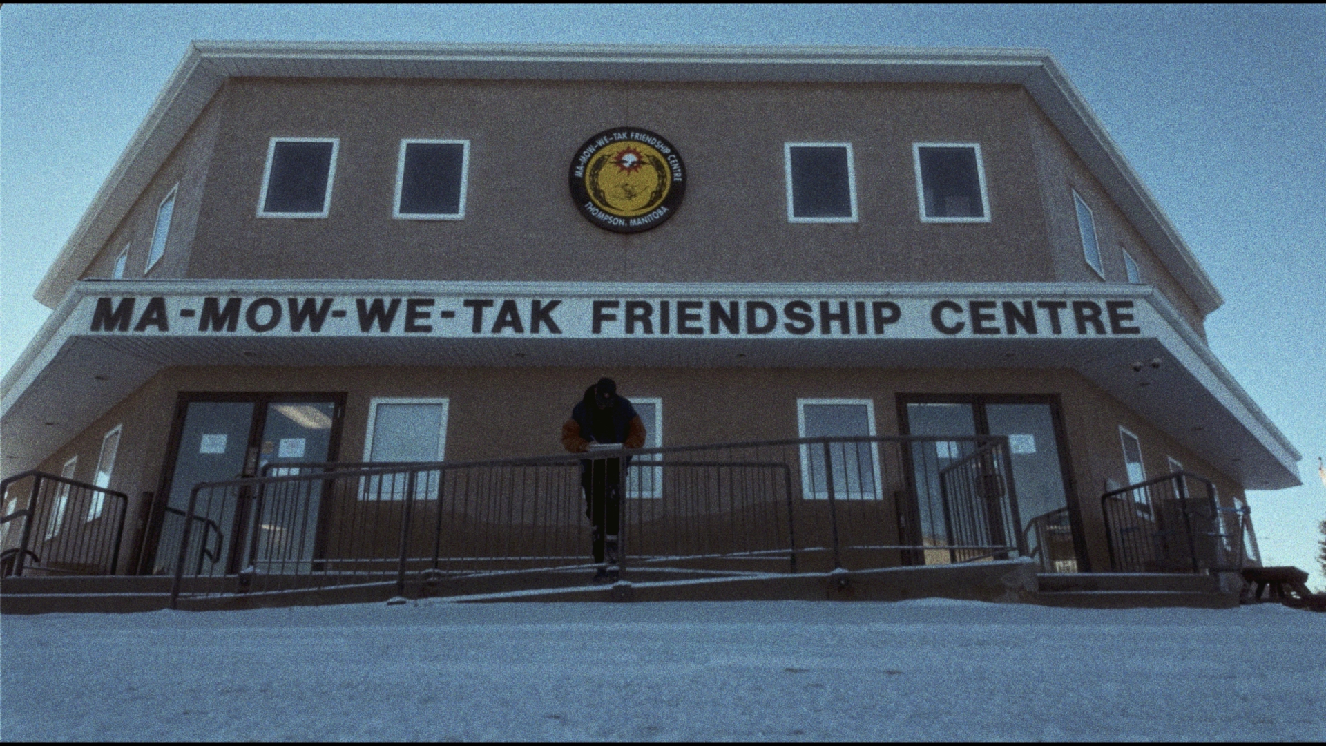A person leans on a wheelchair ramp rail in front of the Ma-mow-we-tak friendship centre in Thompson, Manitoba
