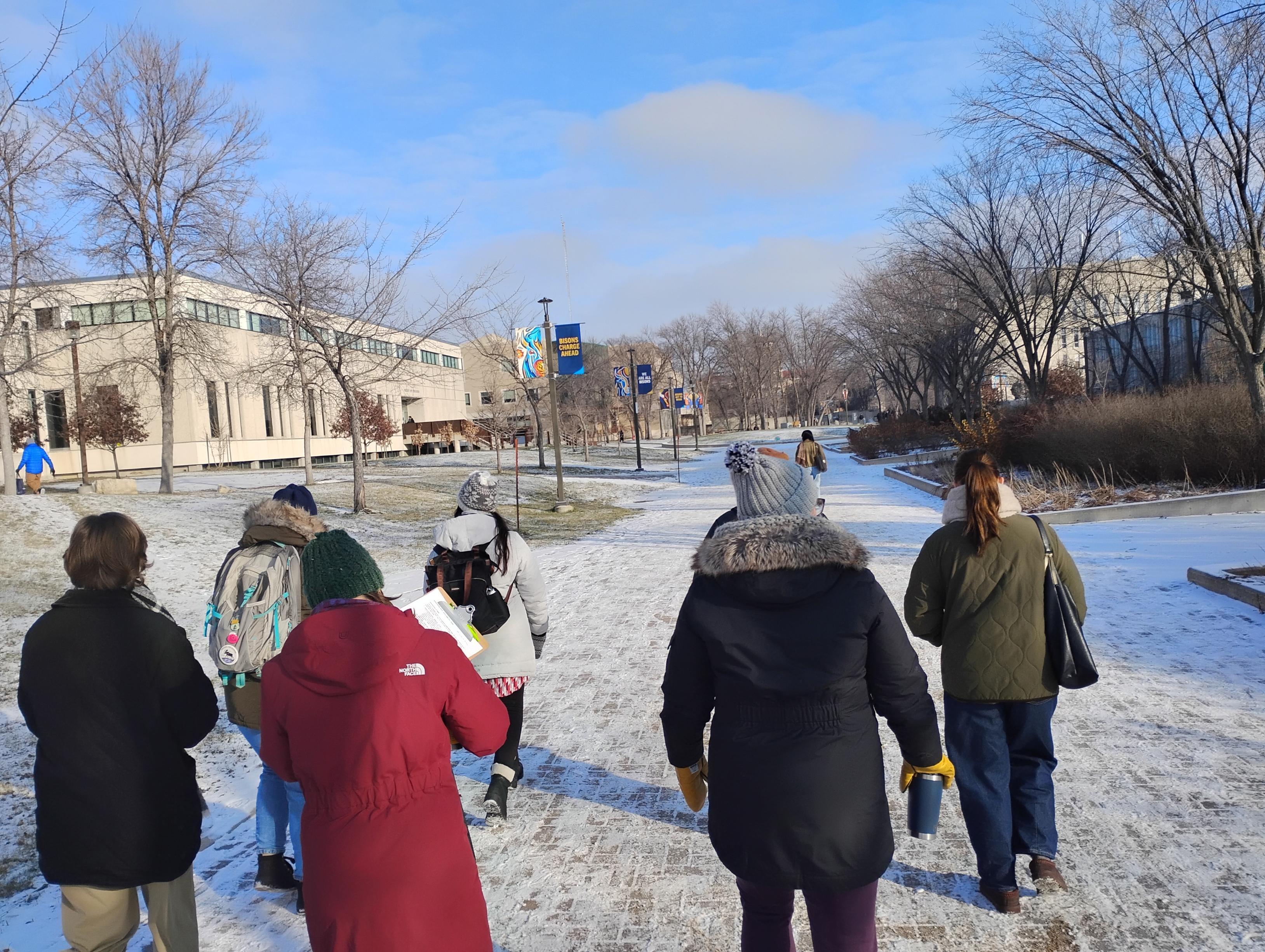 Sustainability Ambassadors walk along Currie Place in winter.