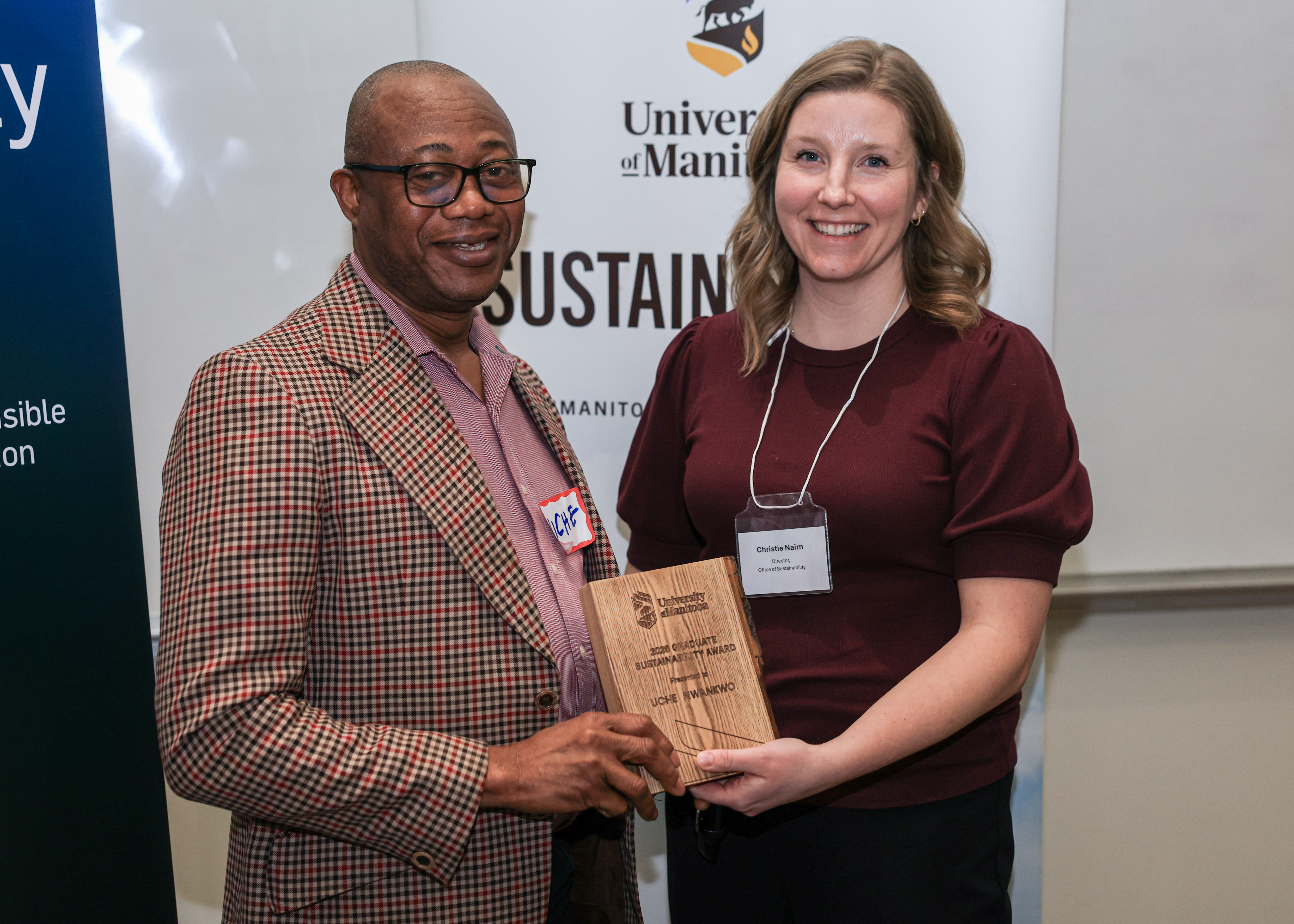 Uche Nwankwo accepts wooden plaque from Christie Nairn