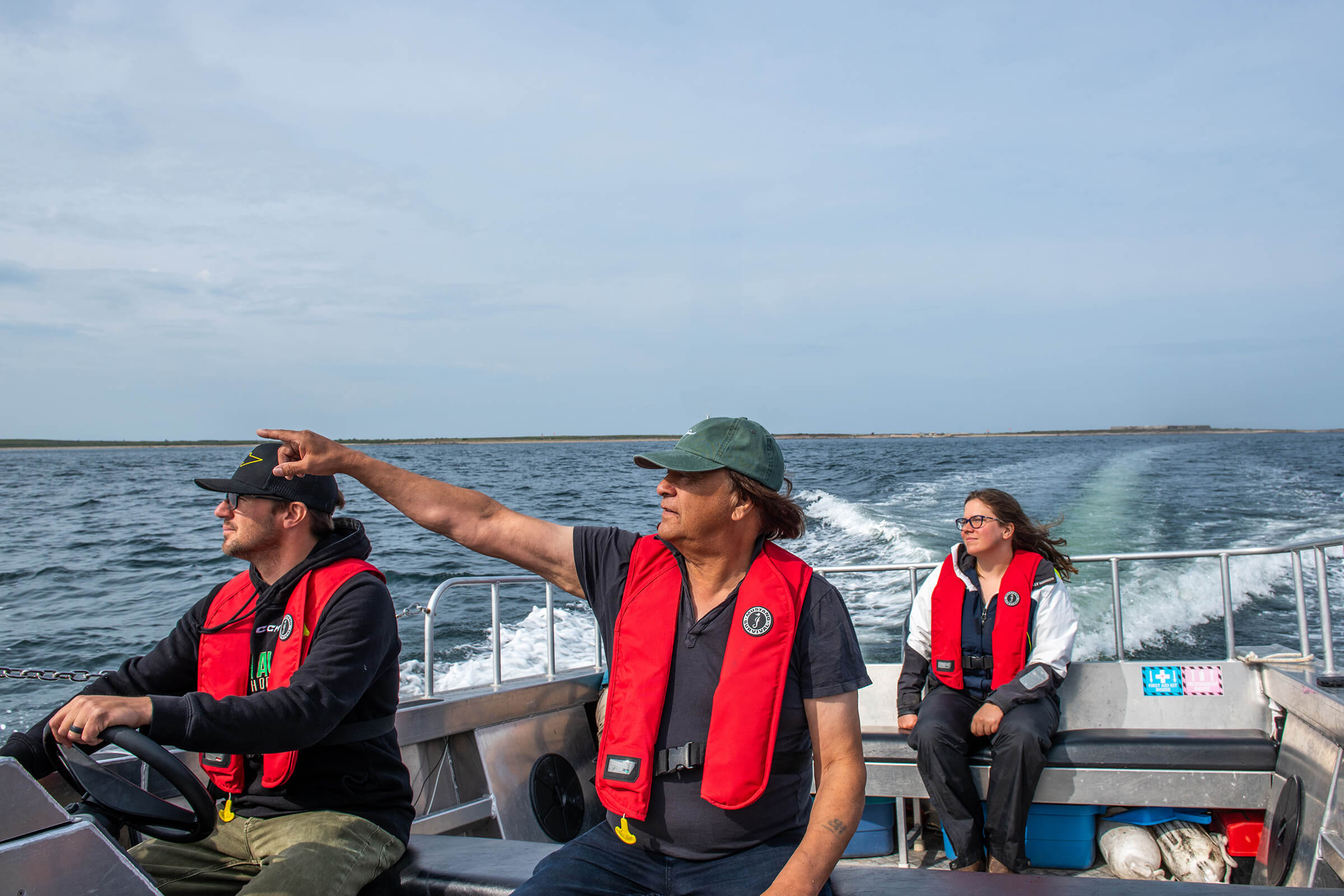 Three people on a small boat.