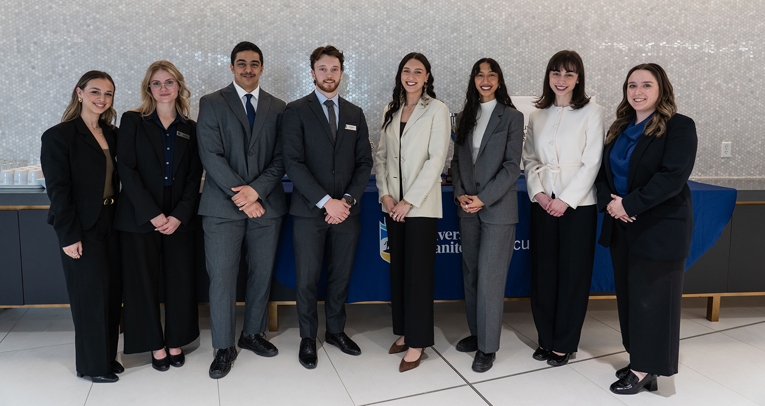A group of law students wearing suits stand in a row