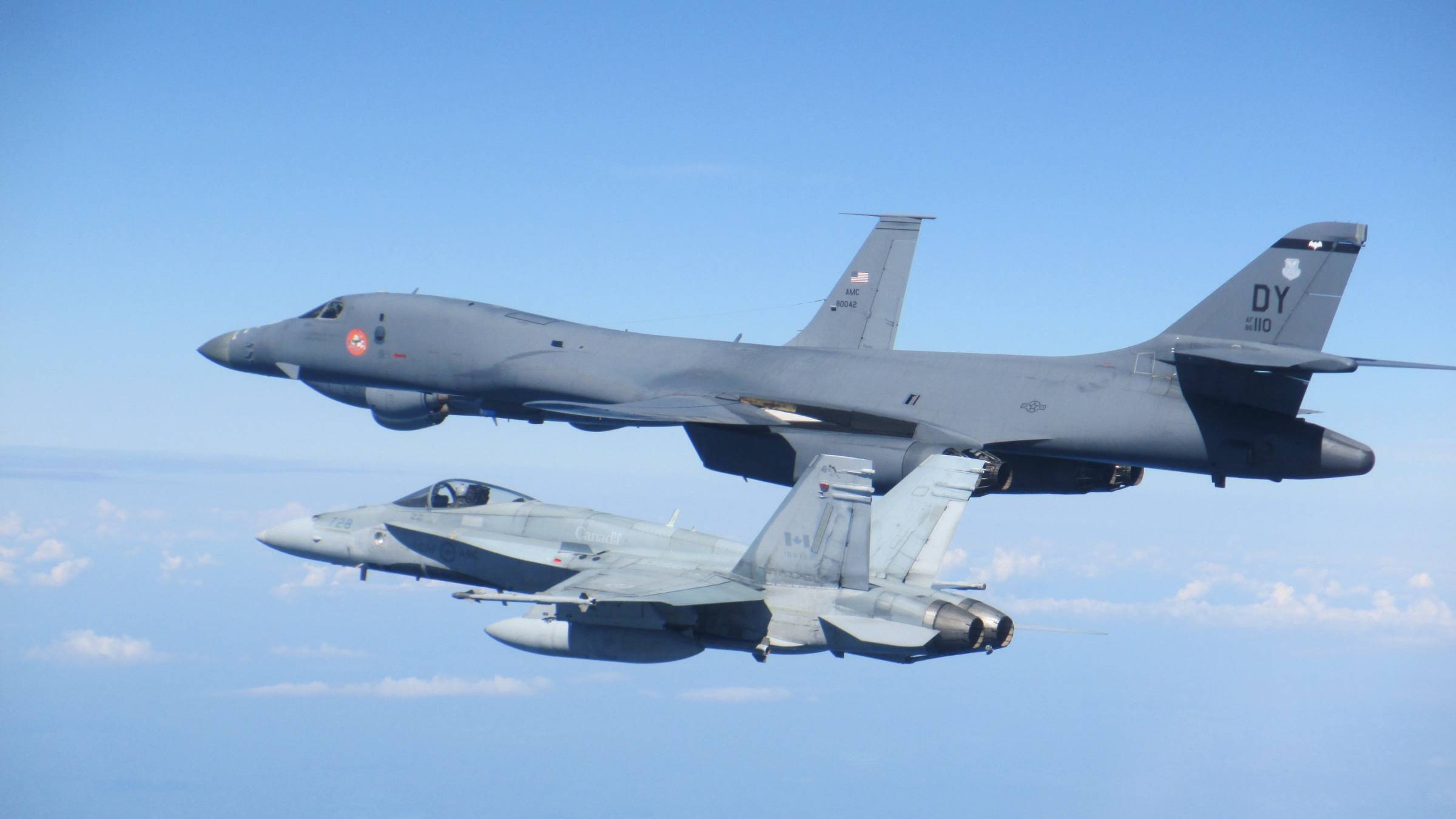 Two military aircraft in the air. 