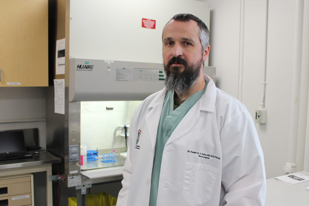 Portrait of Dr. Frederick Zeiler wearing a lab coat in his lab. 