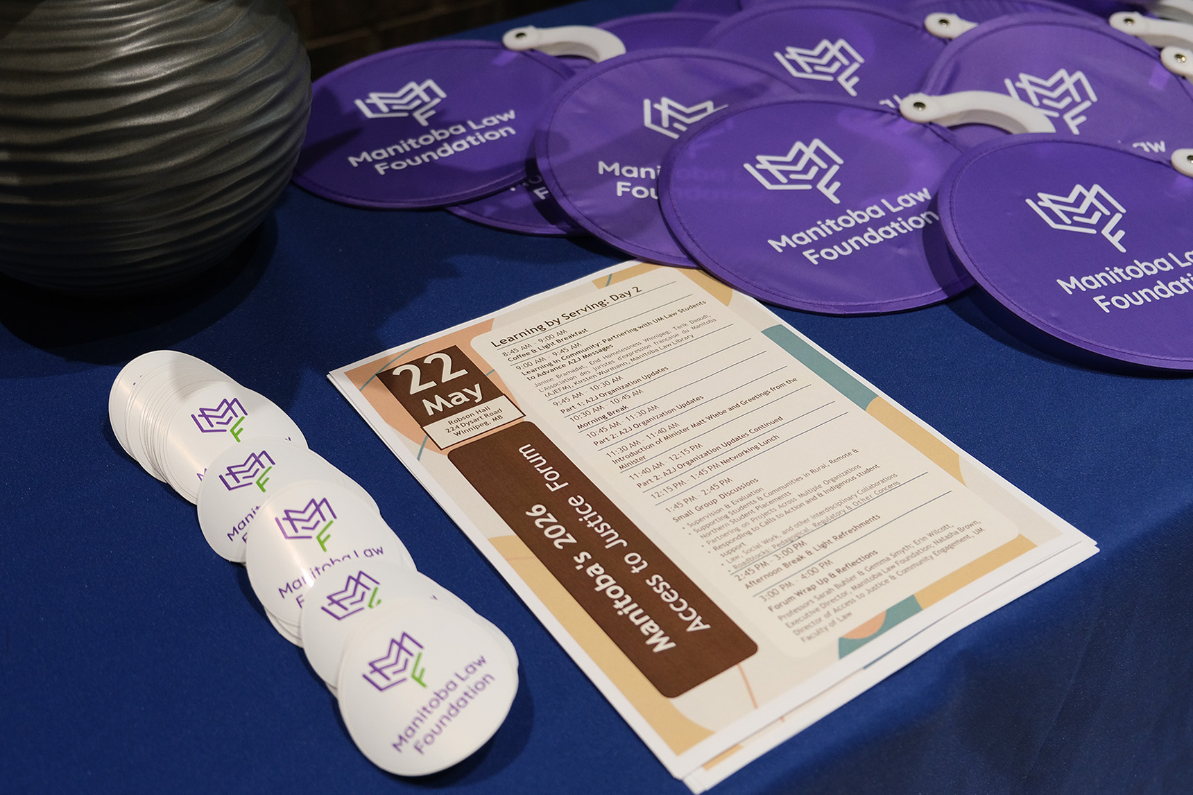 Manitoba Law Foundation stickers and swag on a table with access to justice forum schedule