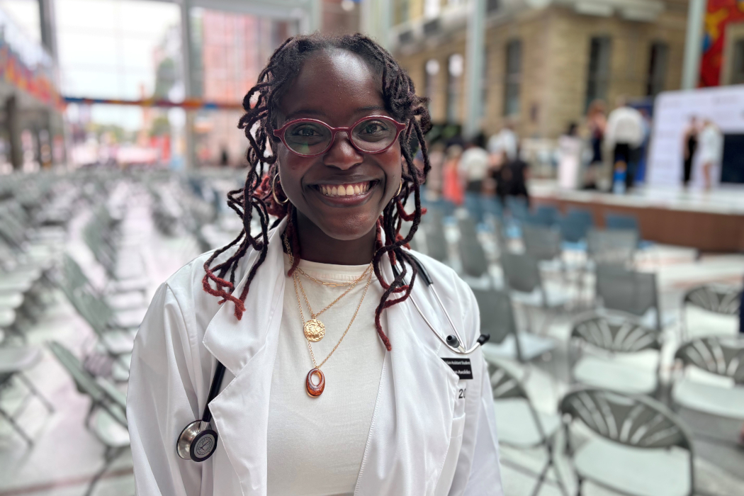 Tinu Tope-Awofeko poses for a photo wearing a white coat and stethoscope around her neck.