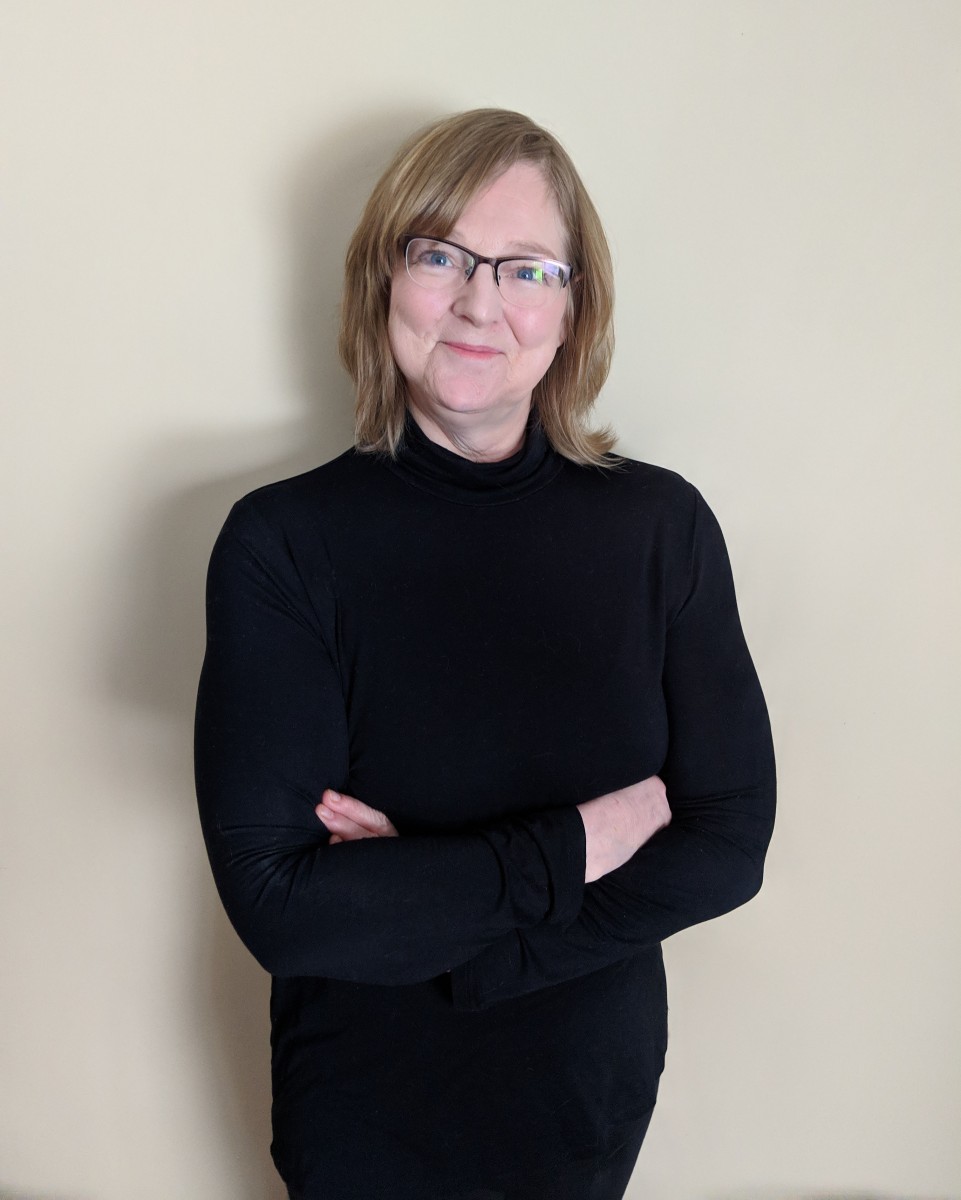 Woman in black with arms folded'