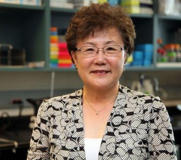 Dr. Miyoung Suh, smiles, posing for a portrait in her lab 
