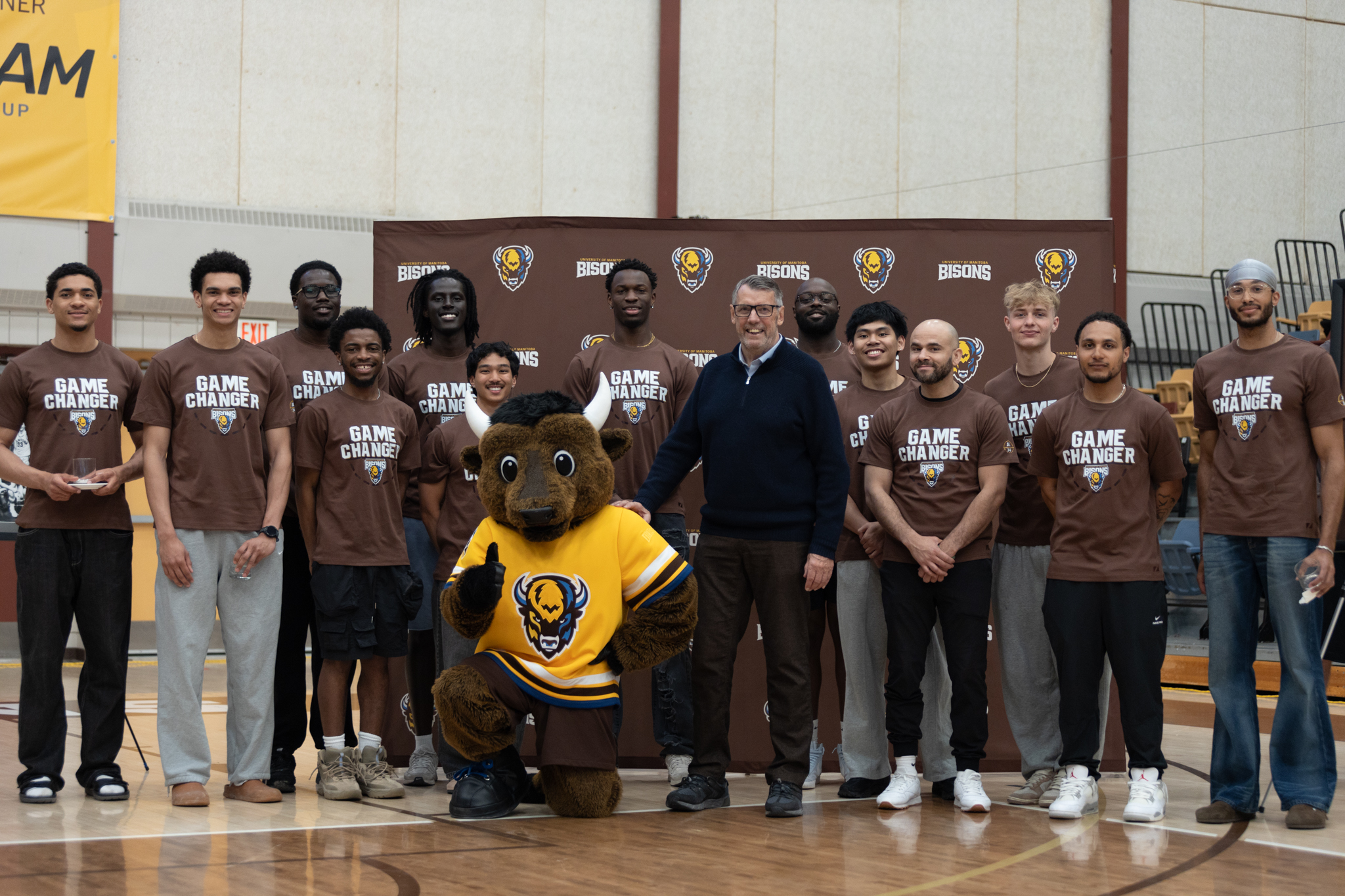 John Loewen with Billy the Bison and the men's basketball team