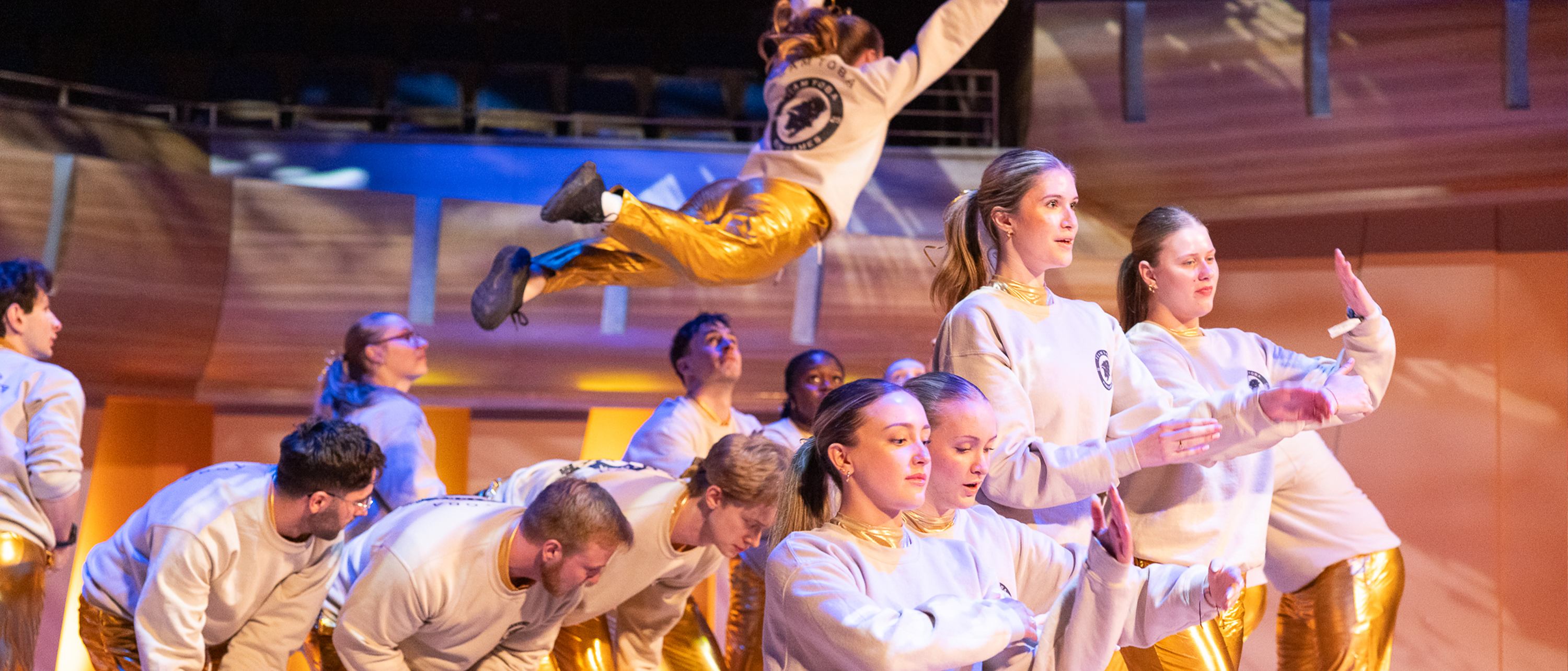 A group of students in gold lamee perform a dance routine at the 2025 Kin Games.