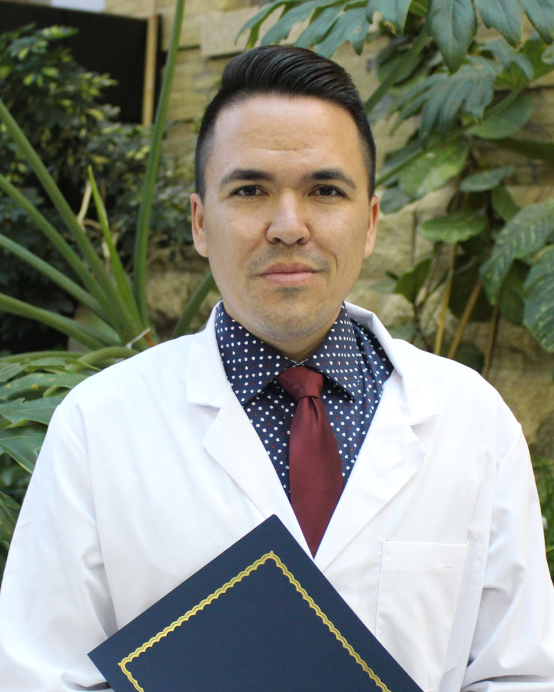 Portrait of Cody Magun. He is wearing a white coat.