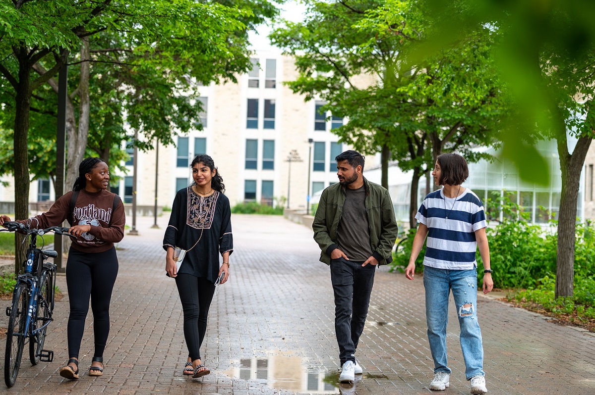 Student ambassadors walk under a tree canopy. 