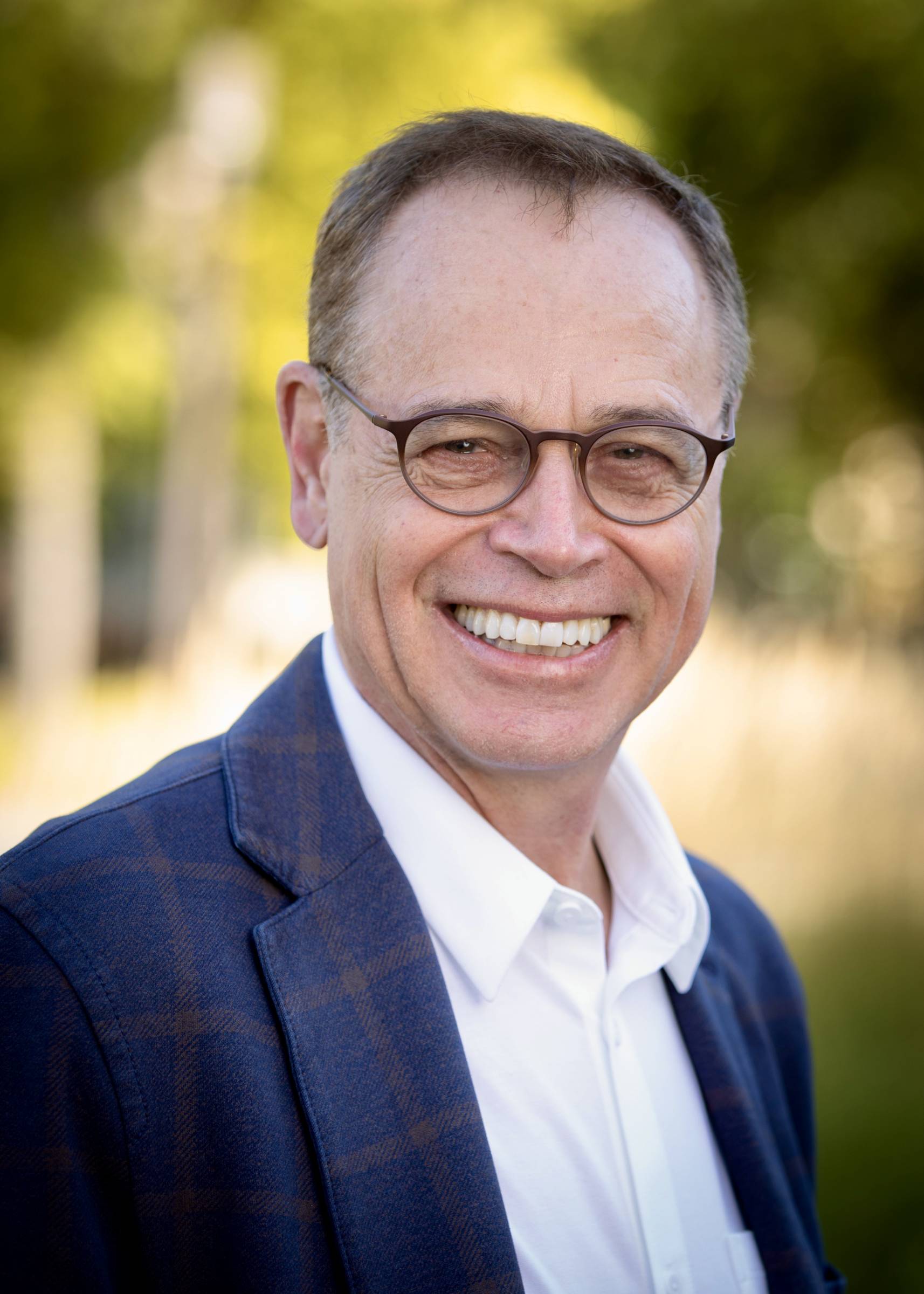 Smiling man with glasses wearing jacket
