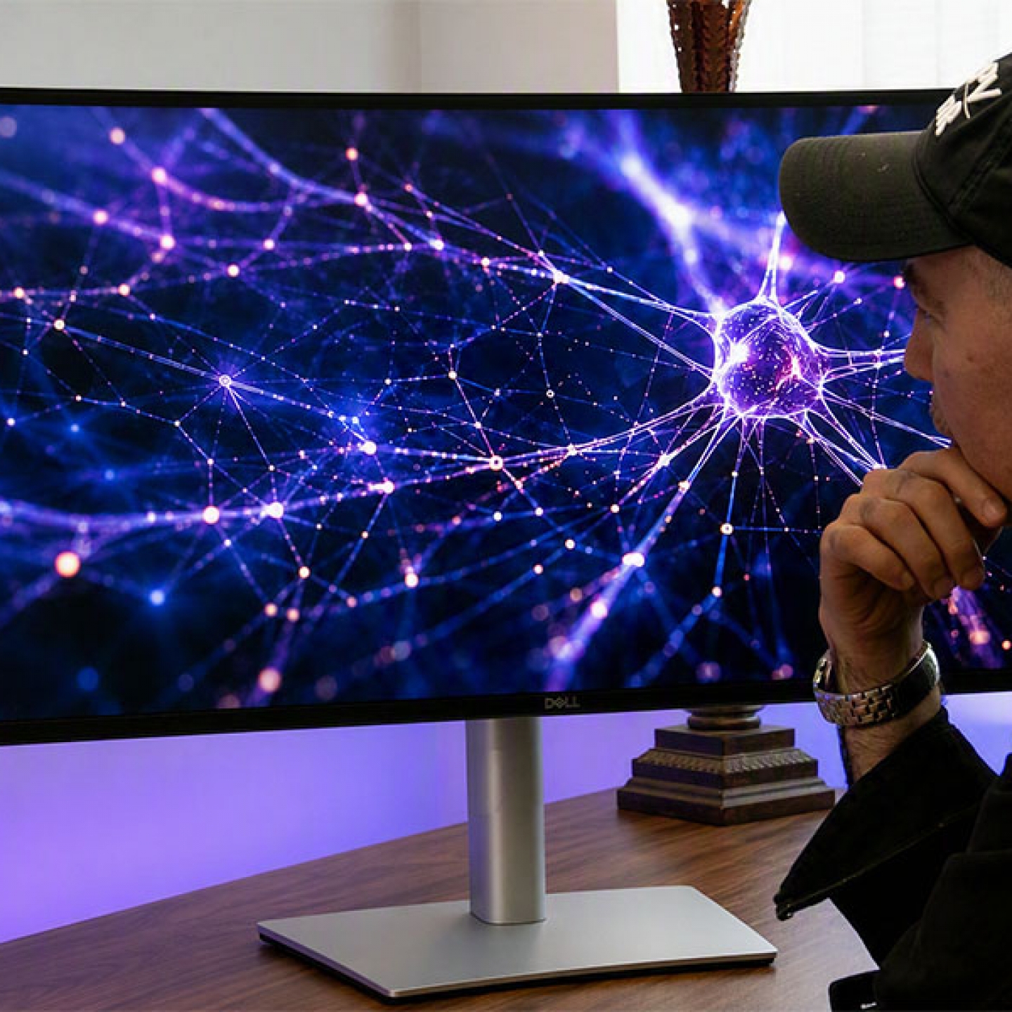 Person with hat stares at screen with digital image of AI