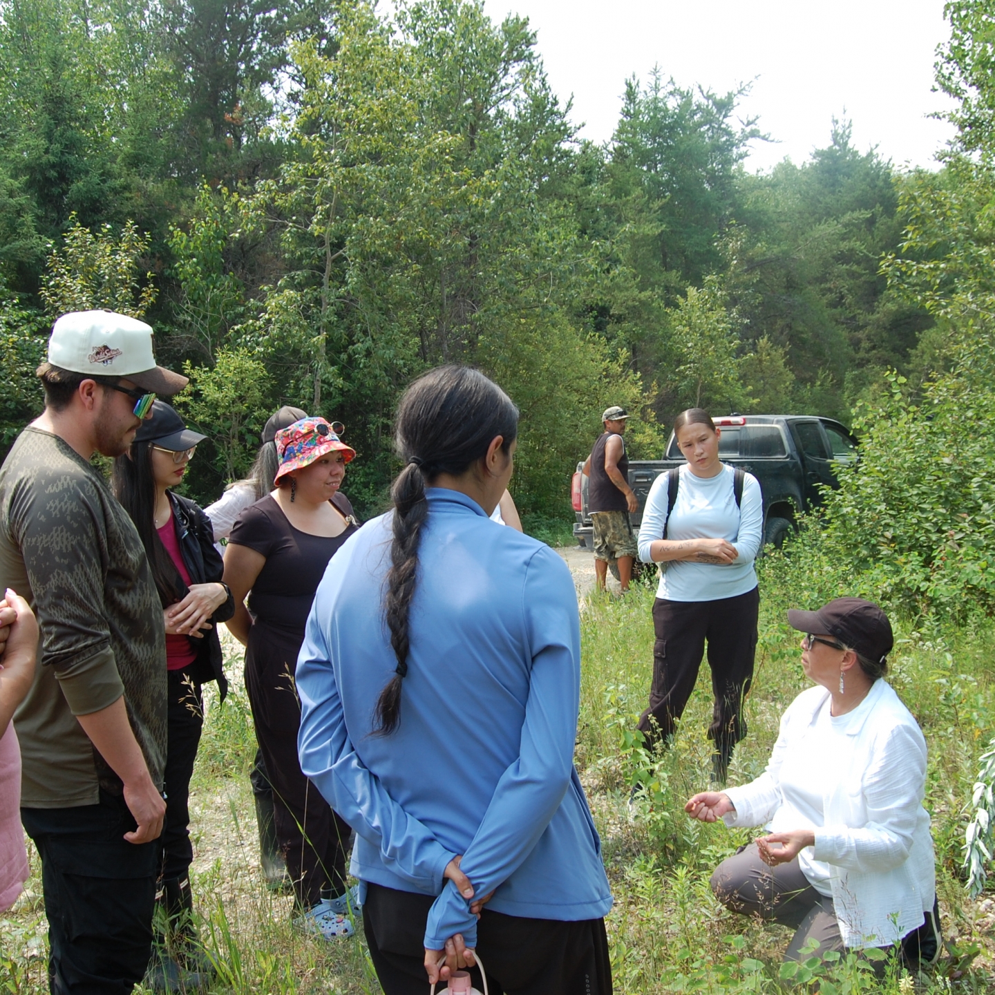 Carla Bird teaching UM students and staff about medicines in a forested area.