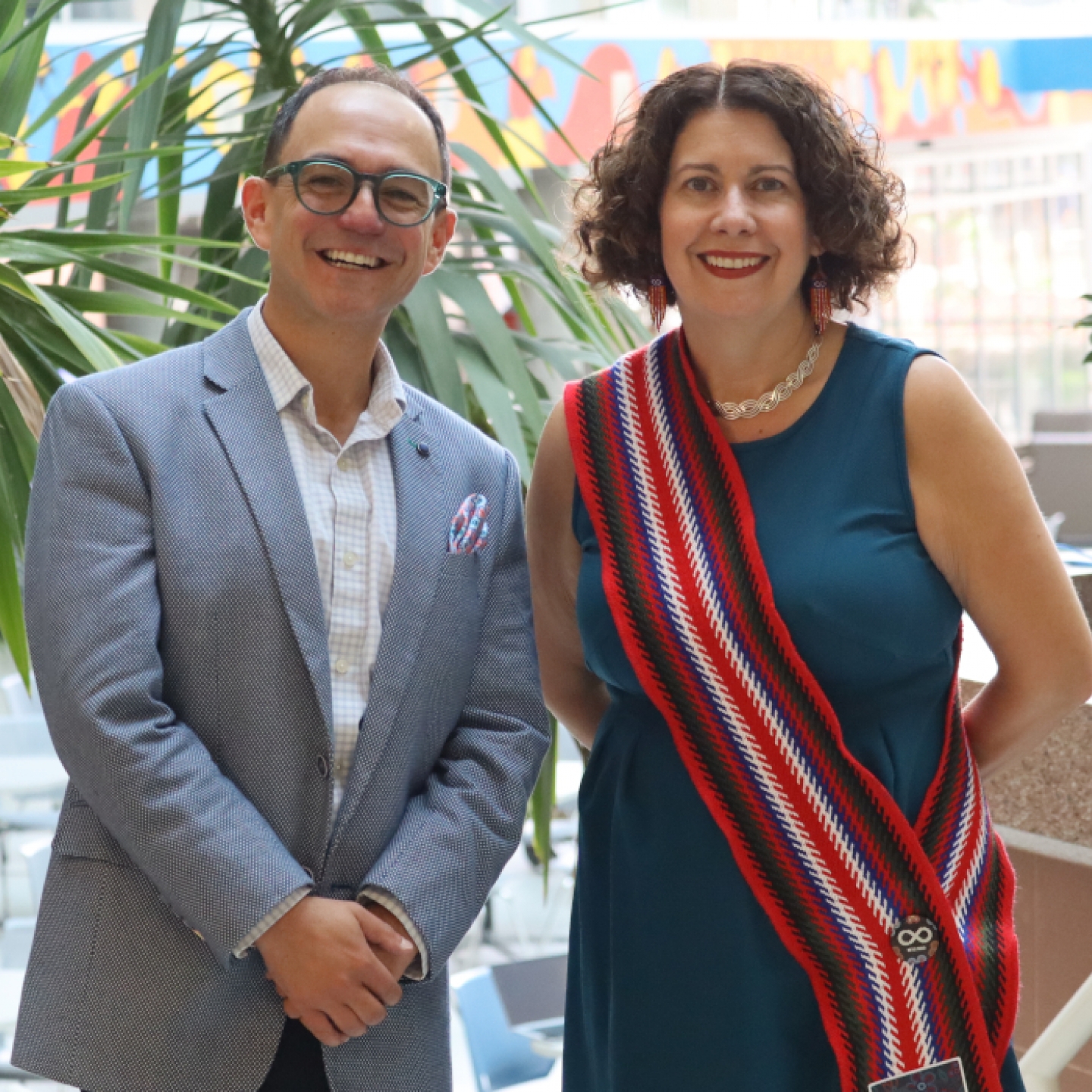 Dr. Michelle Driedger and Dr. Nathan Nickel pose for a photo. Driedger is  wearing a Métis sash.