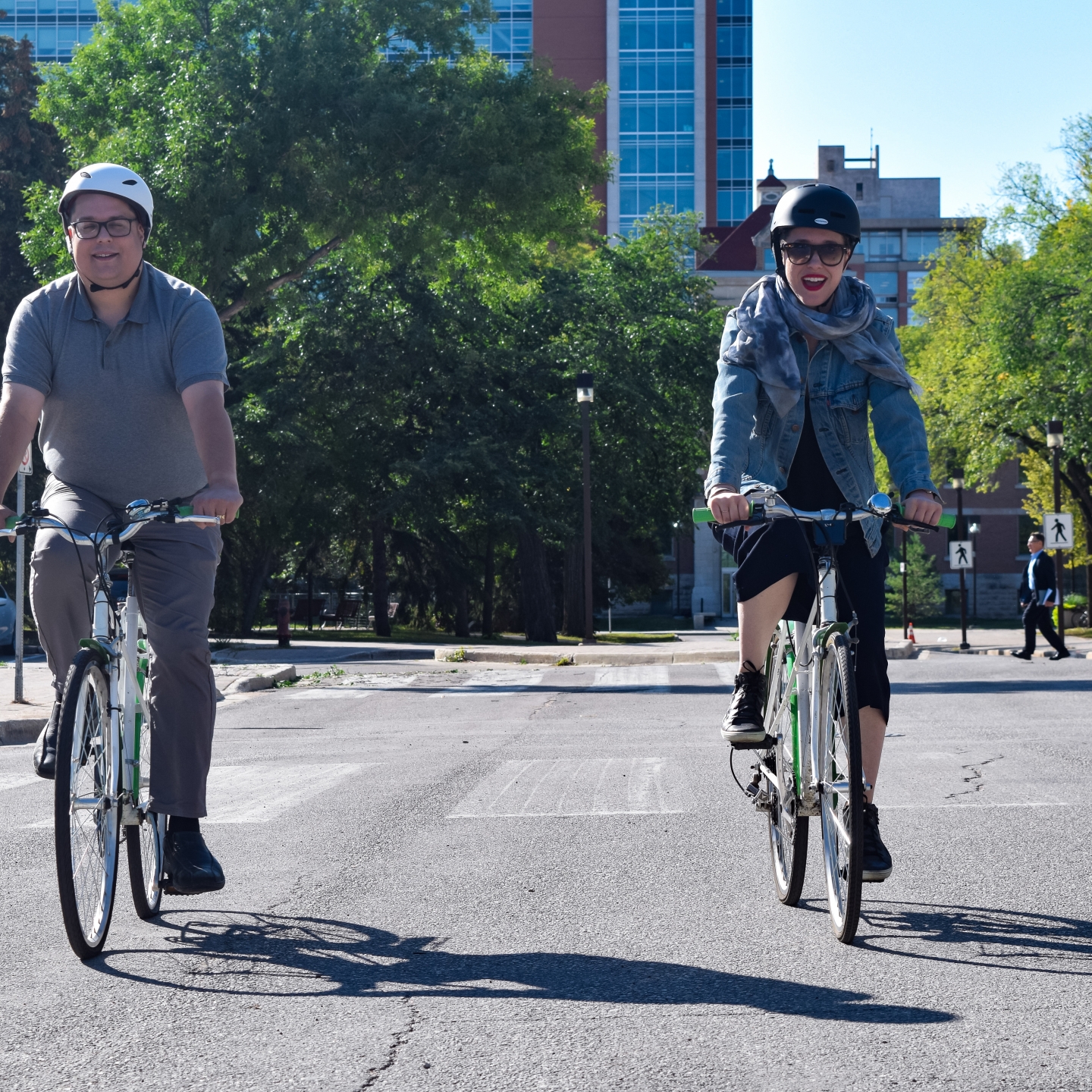 Two people enjoying Fort Garry campus by bike.