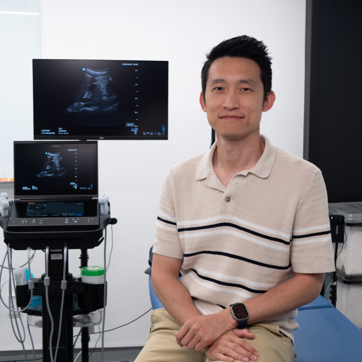 Terry Li sits beside ultrasound machine