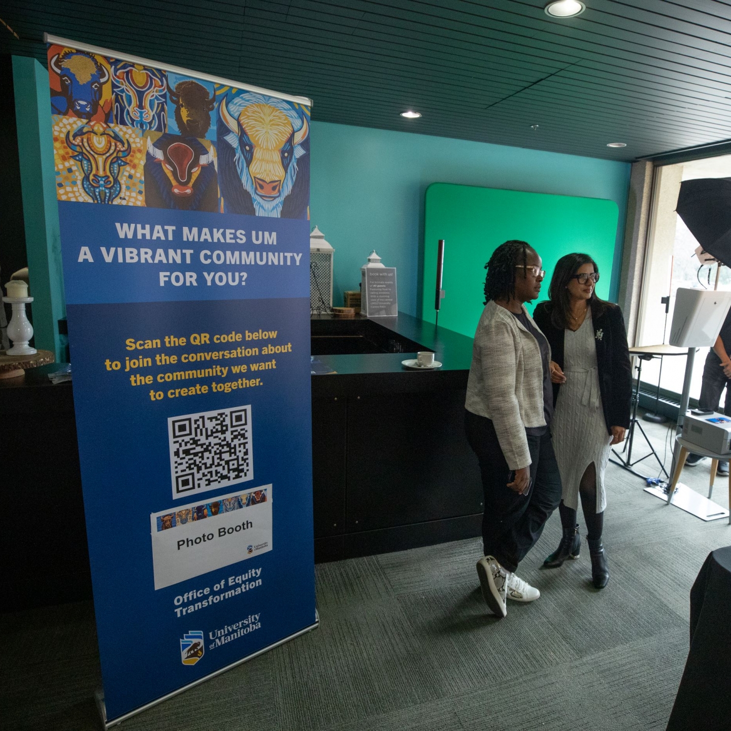 Two people standing beside a banner that says "What makes a vibrant community for you?"