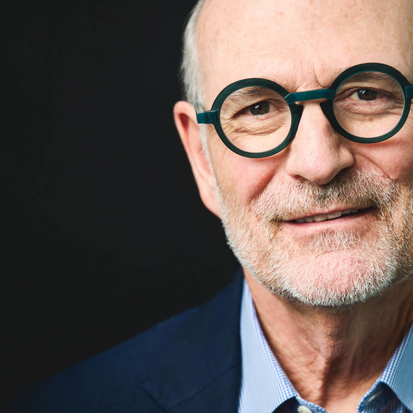 Harvey Chovinov, on a black background, looking at the camera