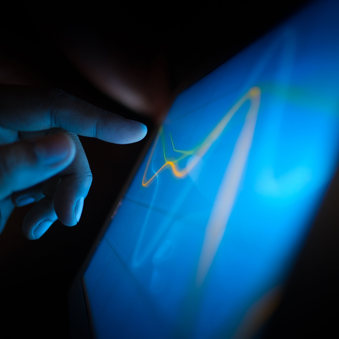 A finger touching a technology screen