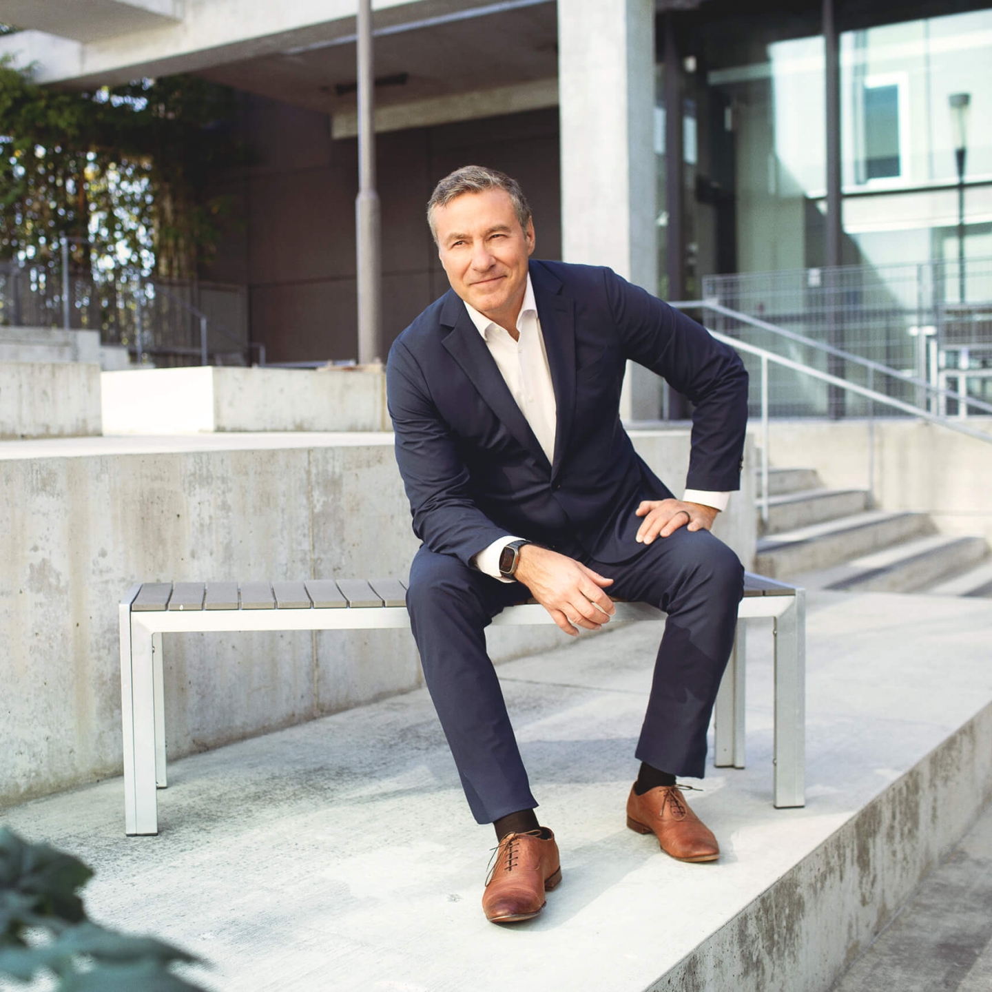 A man in a suit sits on a bench 