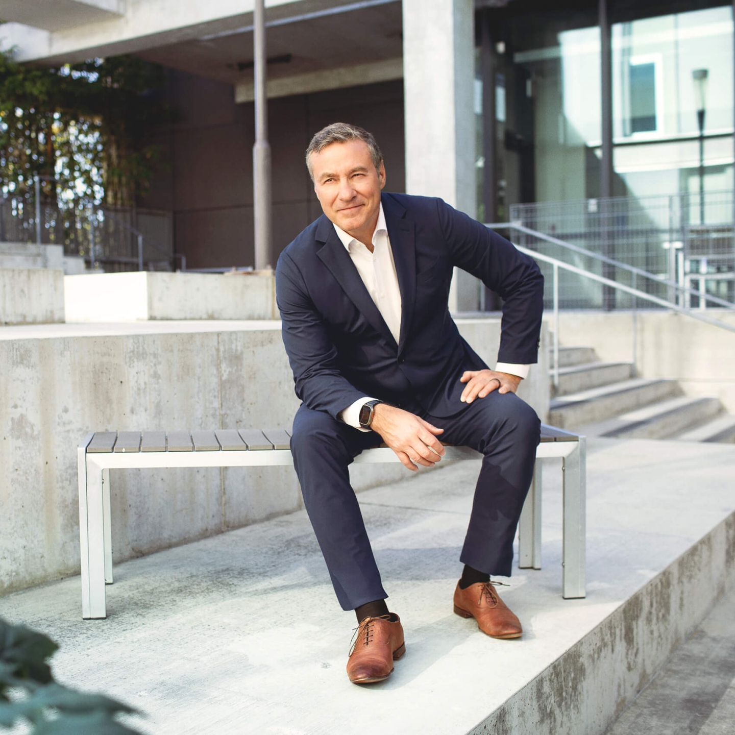 A man in a suit sits on a bench 