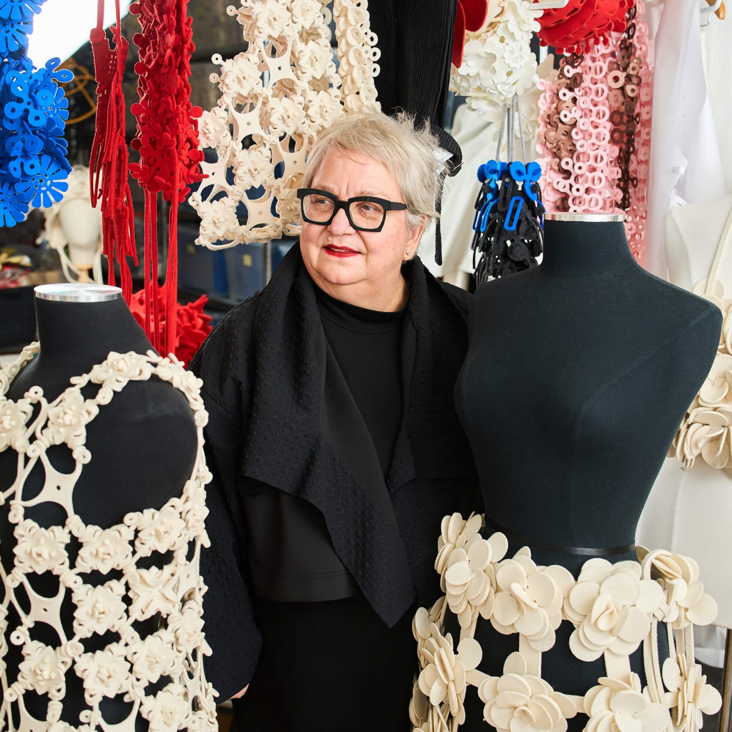 A woman standing in front of fashion designs