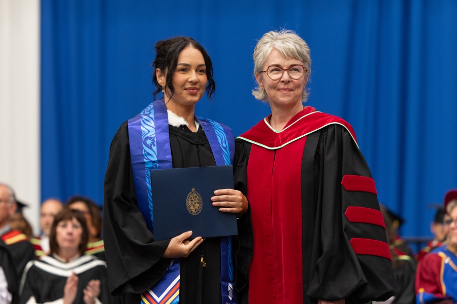 Courtney Chartrand on the convocation stage with Dr. Kellie Thiessen.