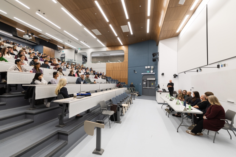 A large group of students attend watch a panel discussion.