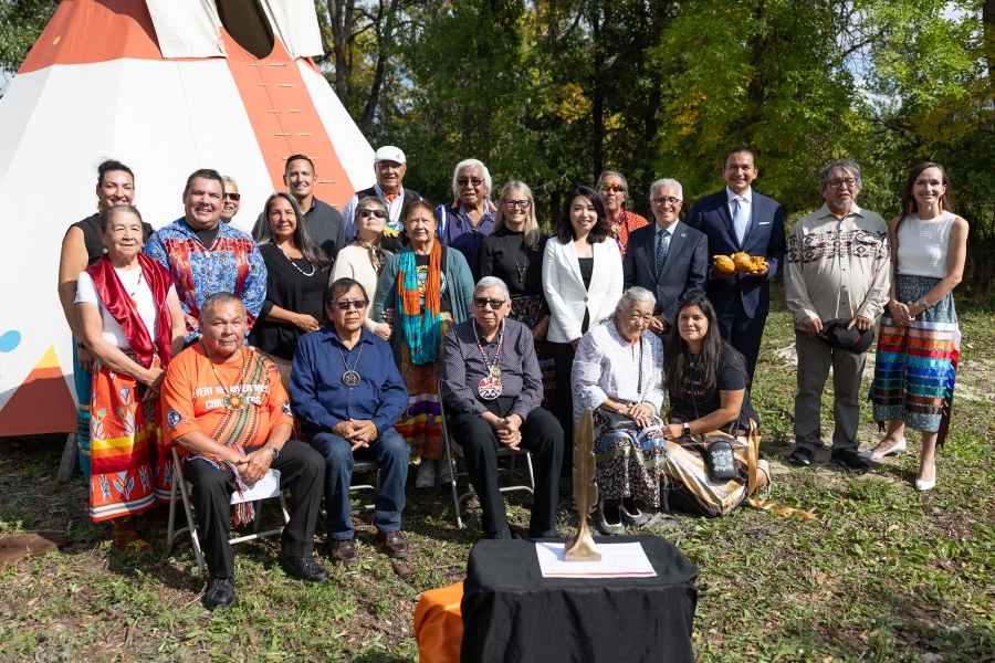 Group of Elders, Survivors, NCTR staff and UM staff outside in front of a teepee
