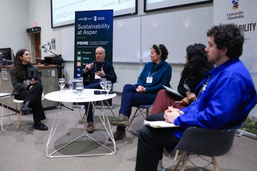 Four panelists and a moderator sit around a circular table.
