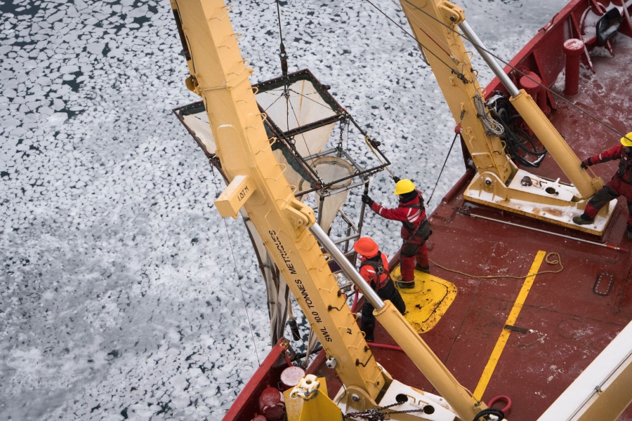 Researchers in red suits on the deck of am ice-breaking ship