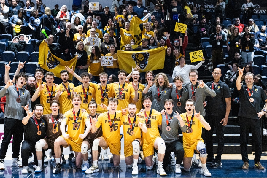 The UM bisons men's volleyball team celebrating together with their USPORTS bronze medals.