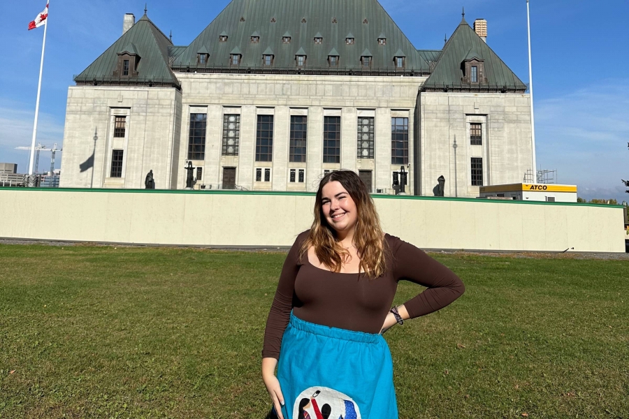 A female standing in front of a building