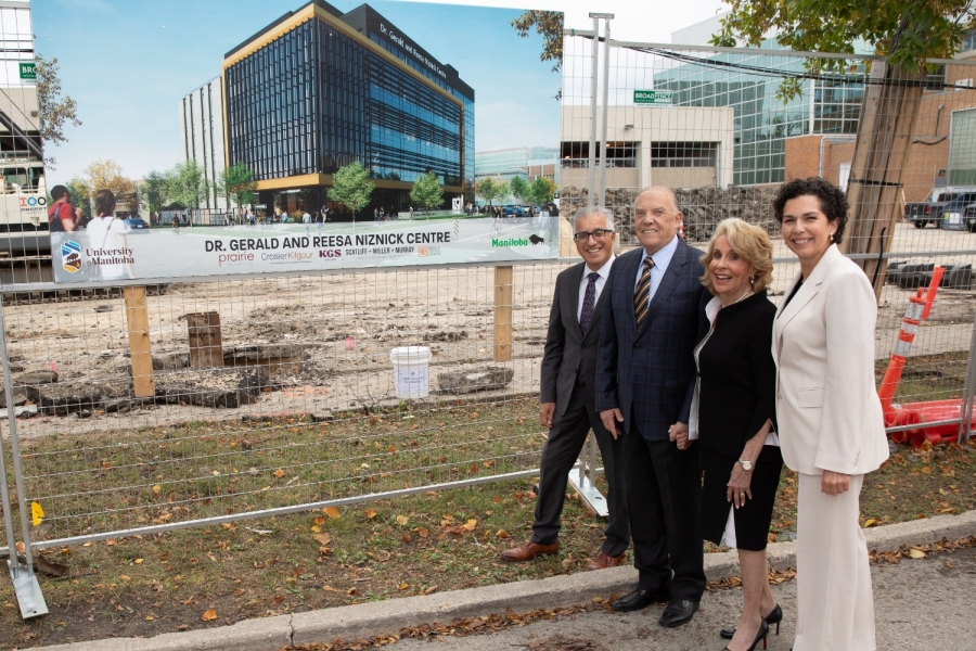 Michael Benarroch, Gerry and Reesa Niznick and Dr. Anastasia Kelekis-Cholakis stand in front of photo of rendering at construction site