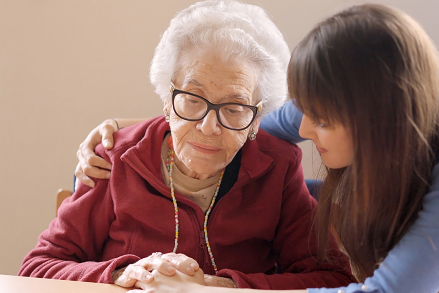 A young woman hugs her grandmother in a nursing home.