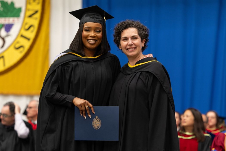 Dr. Sandra Imazenobe wears a graduation cap and gown with Dr. Anastasia Kelekis-Cholakis.