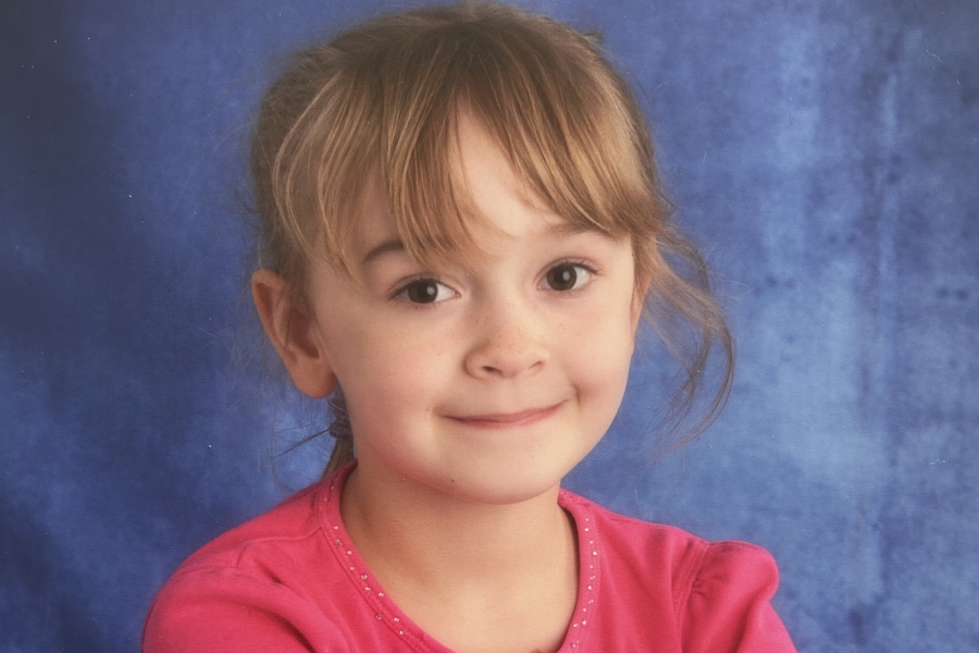 A young girl poses for a school photo.