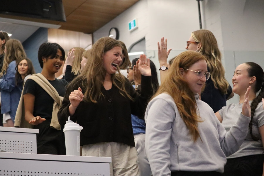 Students in a line, shaking hands and giving high-fives.