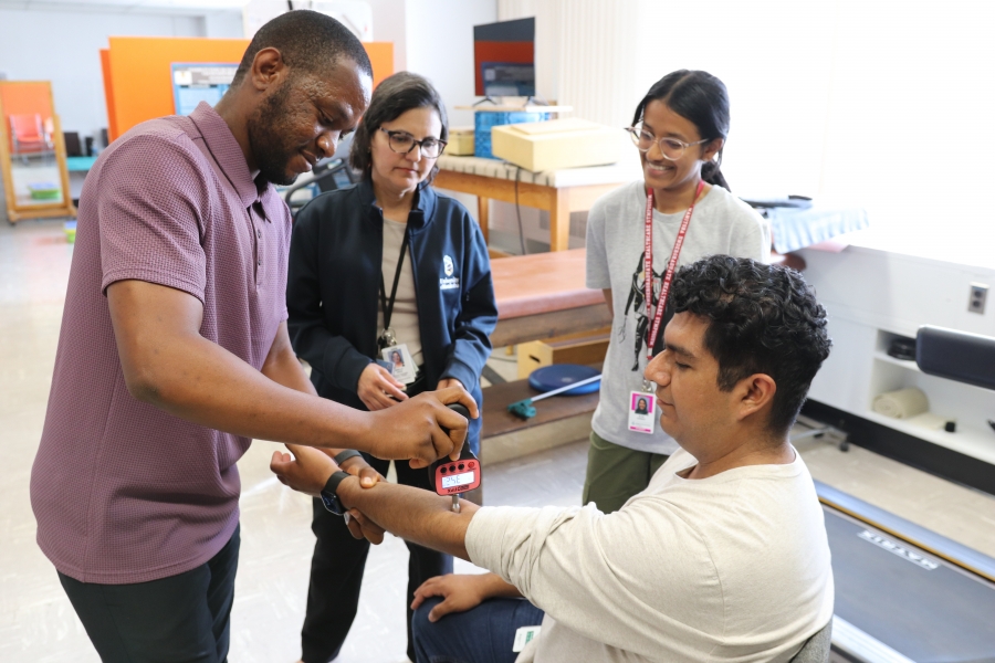 Dr. Mirella Veras and two students practice a pain assessment using an algometer in the AIRE Lab. 