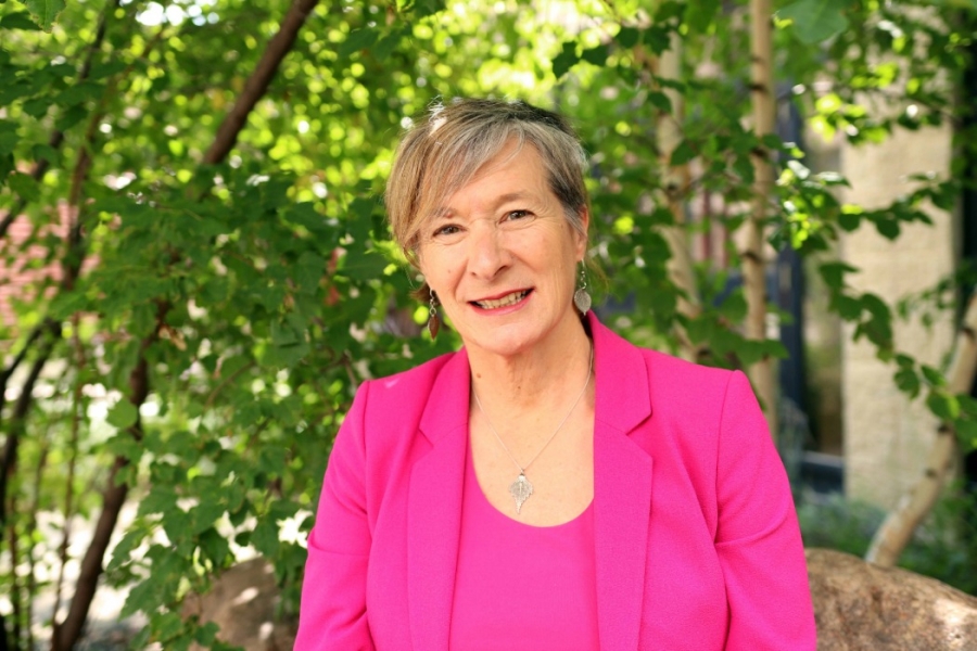 Dr. Josée Lavoie smiling while looking at the camera, with small trees in the background.