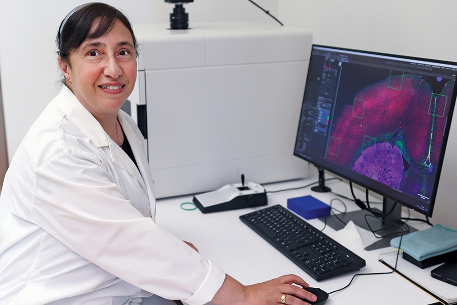 Lucy Marzban smiles at the camera in front of a computer.