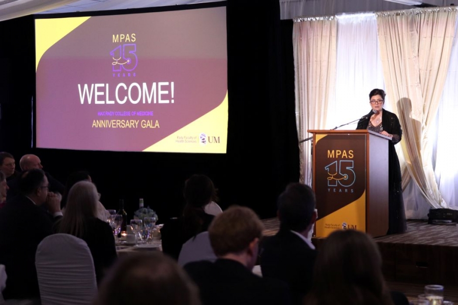Rebecca Mueller speaks at a lectern in front of a crowd at the MPAS gala. 