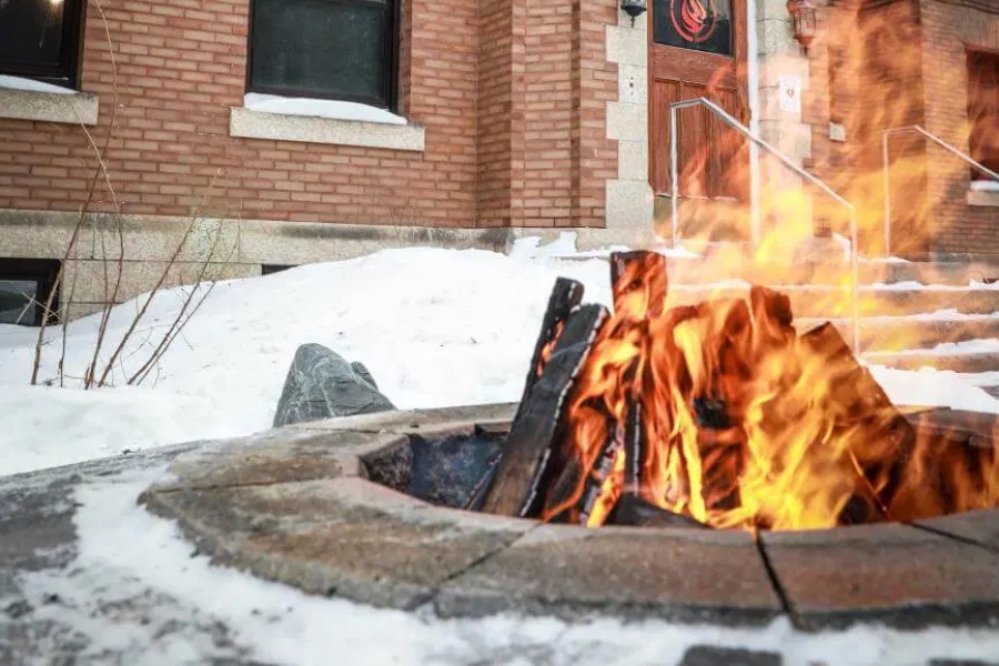 Foreground: sacred fire burns in front of NCTR building in background, winter.