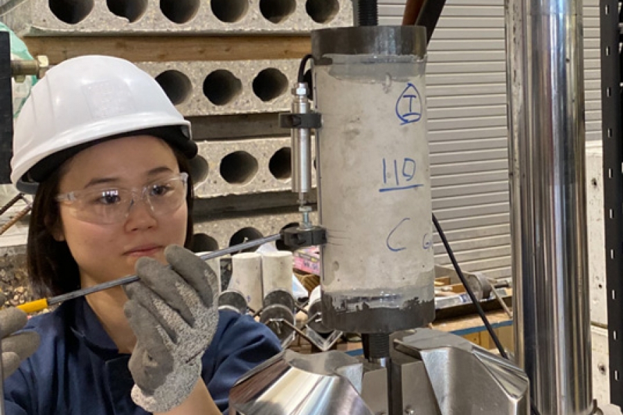 A student in a hardhat working with lab equipment