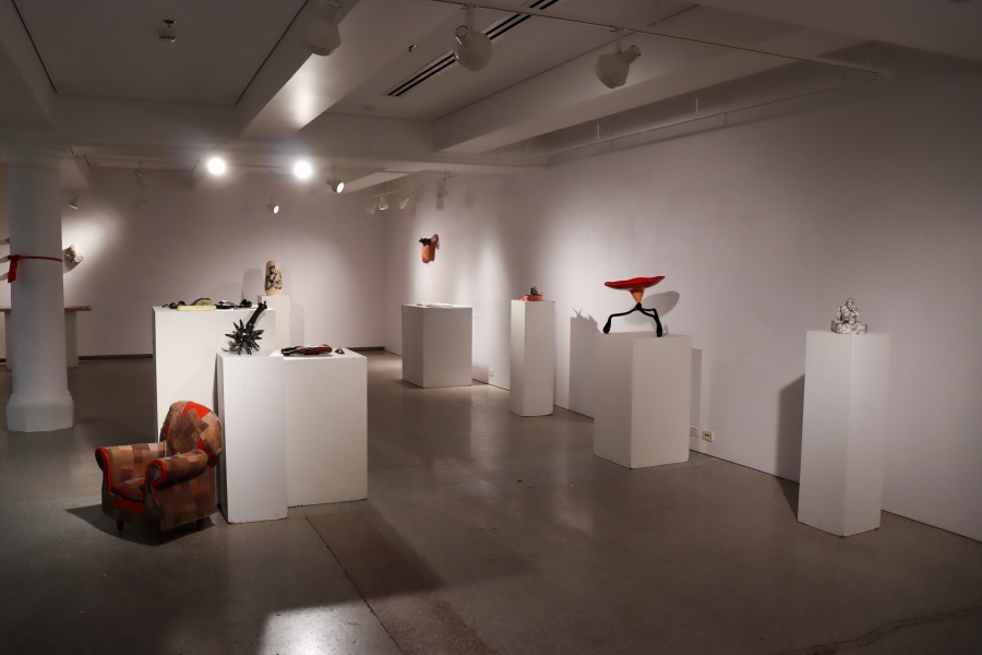 Installation view of the RECLAYM ceramics exhibition in the School of Art Student Gallery, showing sculptural clay works displayed on white pedestals.