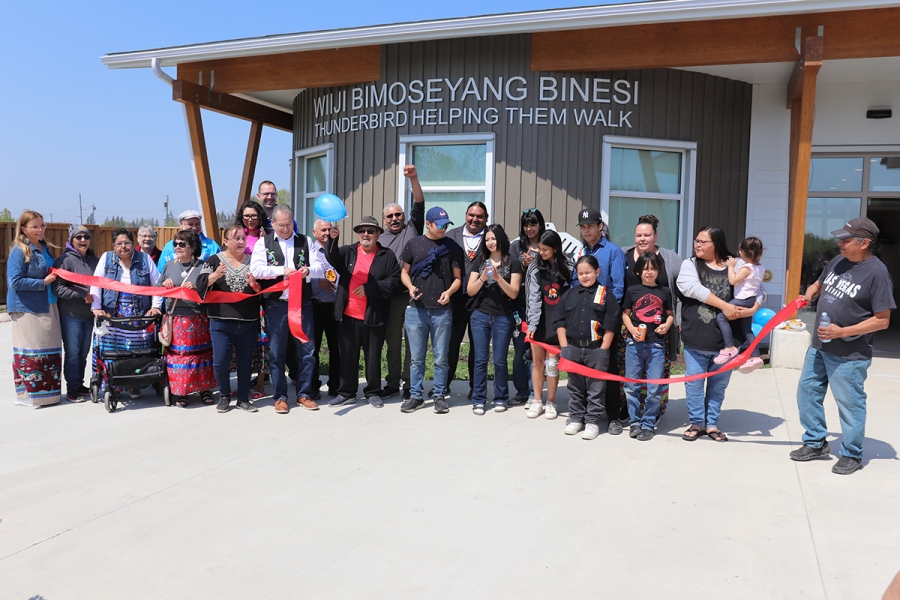 A large group of community members and University of Manitoba representatives at a ribbon cutting in front of the new housing complex in Sagkeeng First Nation.