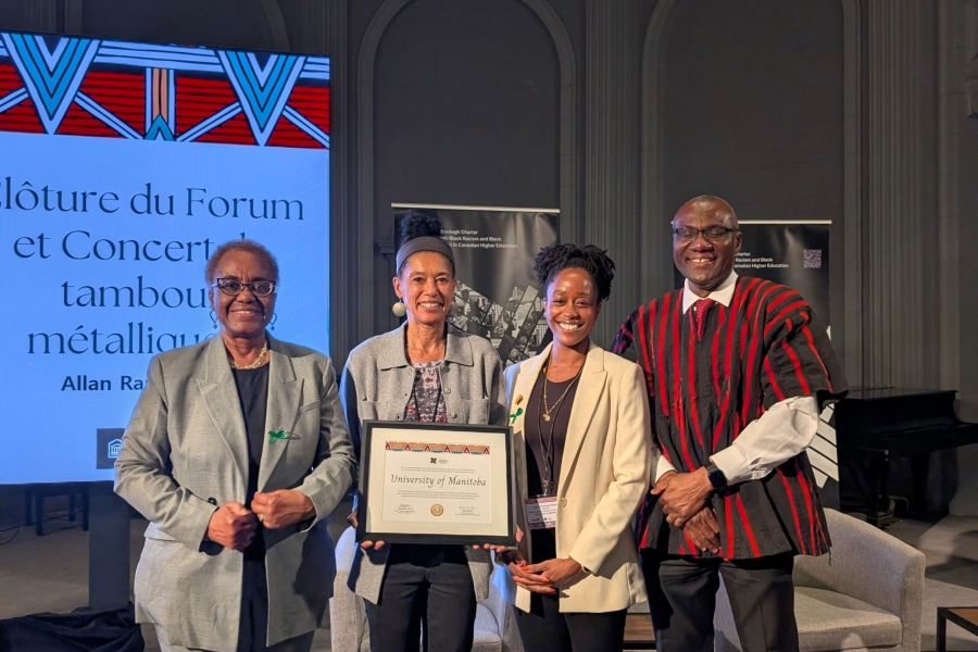 Four individual stand together holding a certificate.