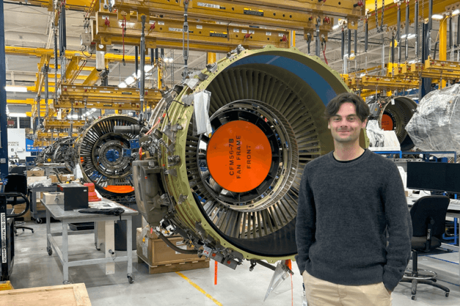 A student standing in a large aerospace work space
